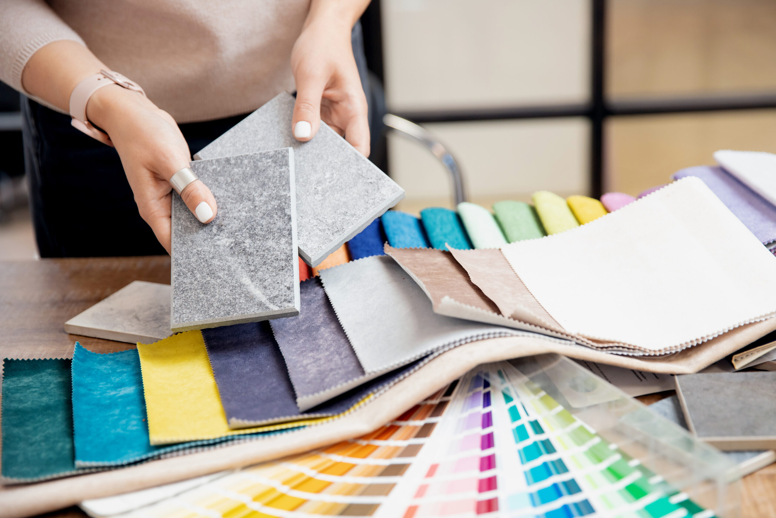 Concept design interior. Top view hand of woman designer chooses set fabrics for curtains in textile.