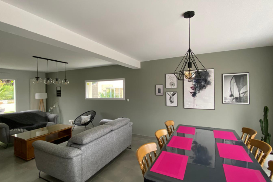 Salon et salle à manger modernes avec murs vert-de-gris, luminaires industriels noirs et décorations murales en noir et blanc Peinture Intérieure Axirenov